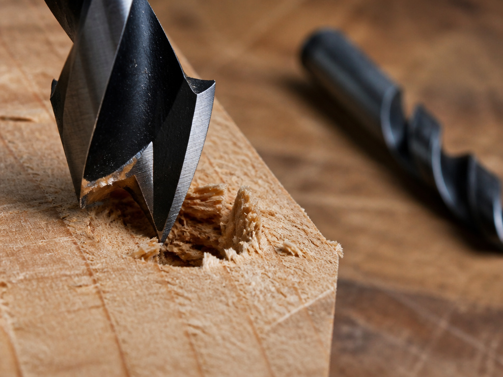 Brad point bit failing on wood end grain versus a clean twist drill bit.